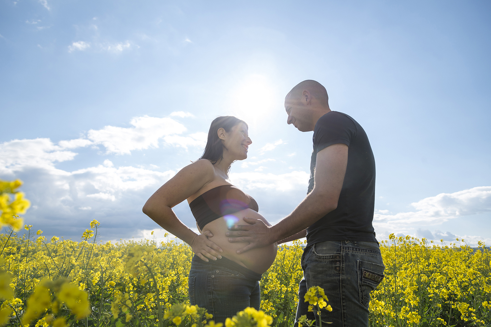 couple femme enceinte dans des champs de colza