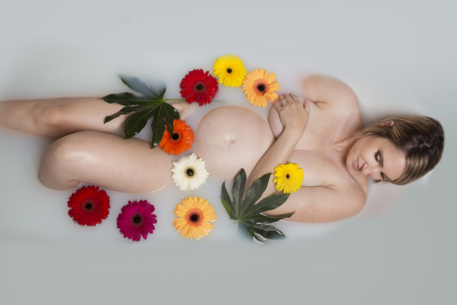 femme enceinte dans un bain de lait avec des fleurs
